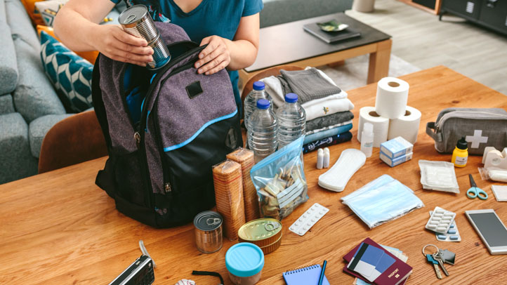 mom packing an emergency go bag for her family with essential supplies