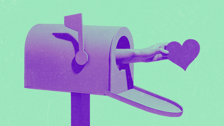 hand holding a heart reaching out of a mailbox