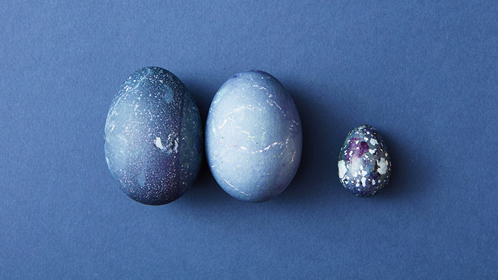 Three light blue eggs on a darker blue background