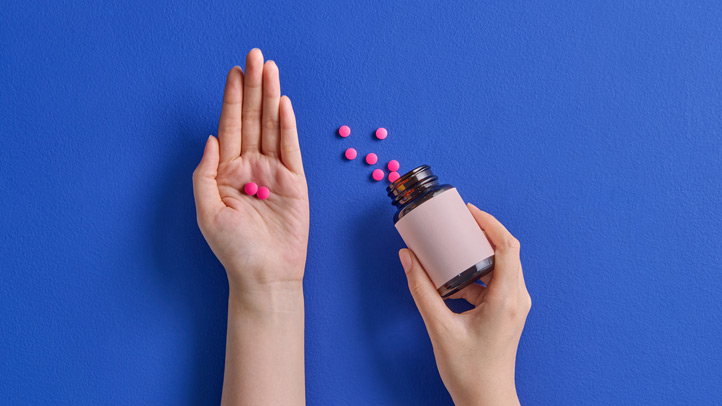 ibuprofen during pregnancy and breastfeeding, hands holding pills from a pill bottle