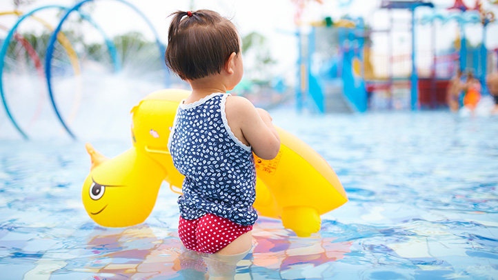 learning to swim age by age, little girl with a float in the pool