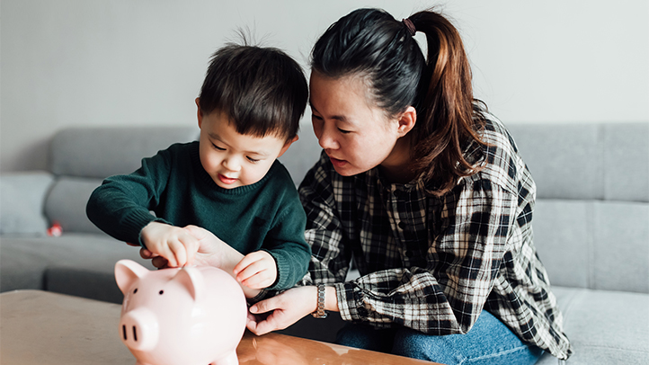 baby savings account, mom and son adding money to a piggy bank