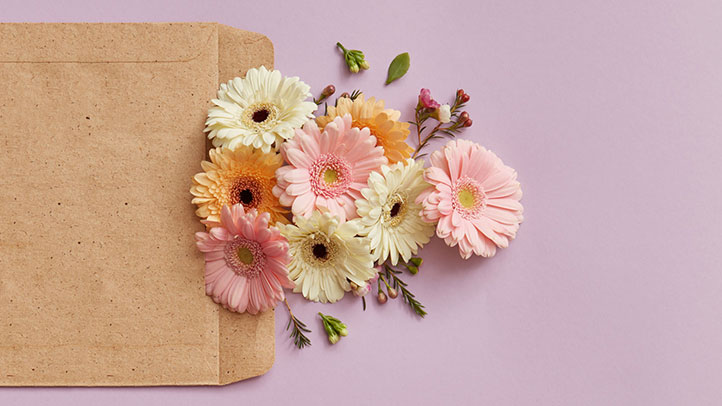 Bouquet of pink and yellow flowers on pale purple background