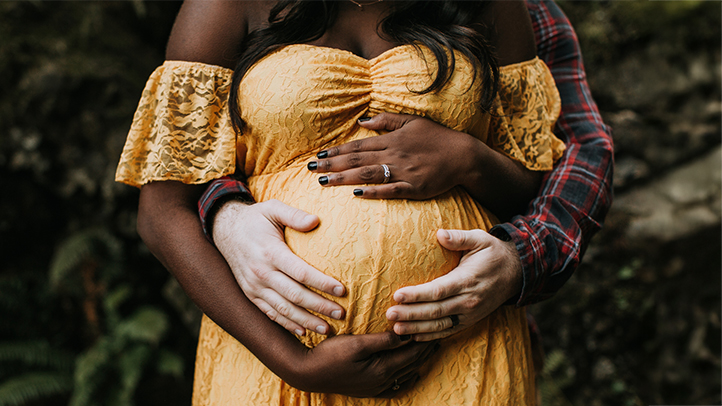 couple holding pregnant belly